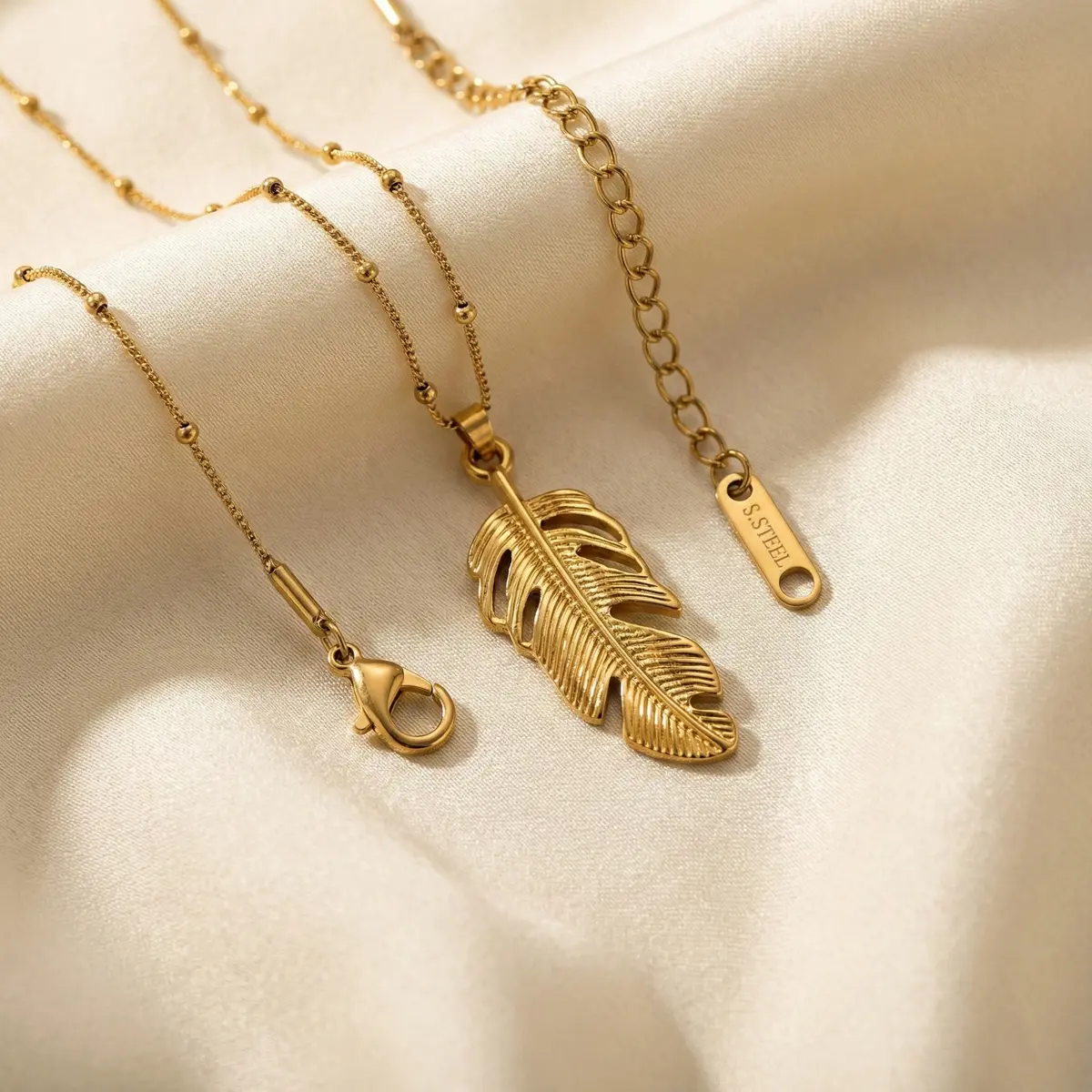 Golden Feather Pendant Necklace on Fabric Look