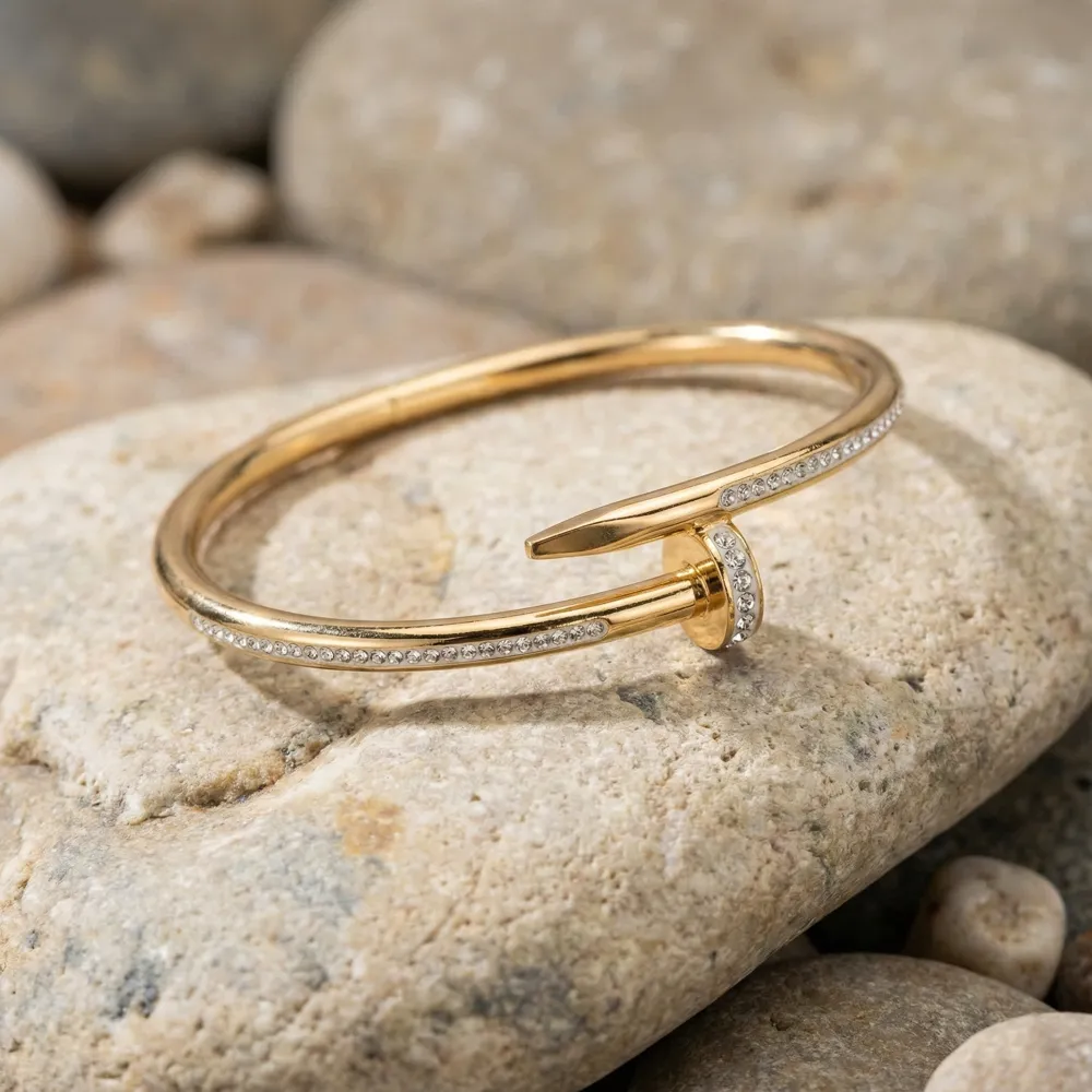 Golden Nail Diamond Studded Bracelet Placed on Cream Stone