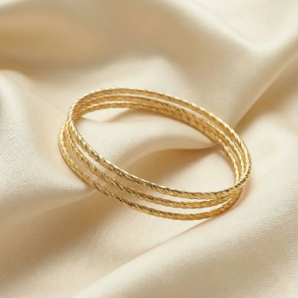 Golden Twist Harmony Bangle Placed on Fabric
