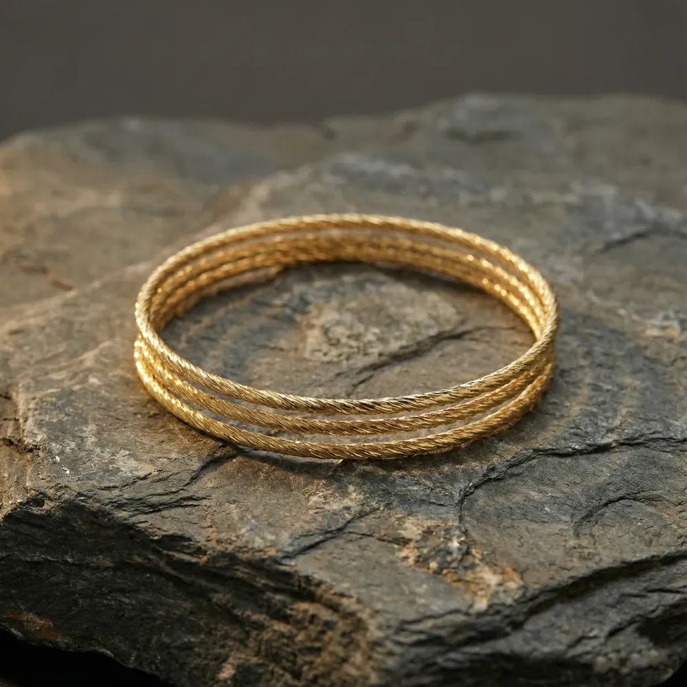 Golden Twist Harmony Bangle Placed on Stone